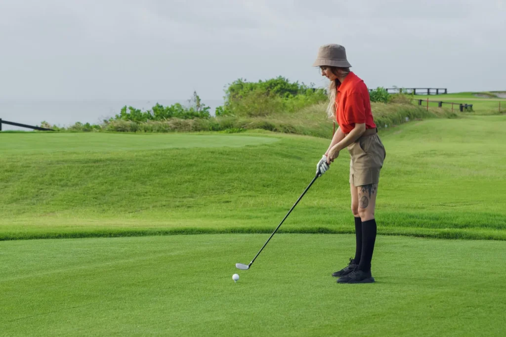 Woman golfer taking a swing on a golf course fairway