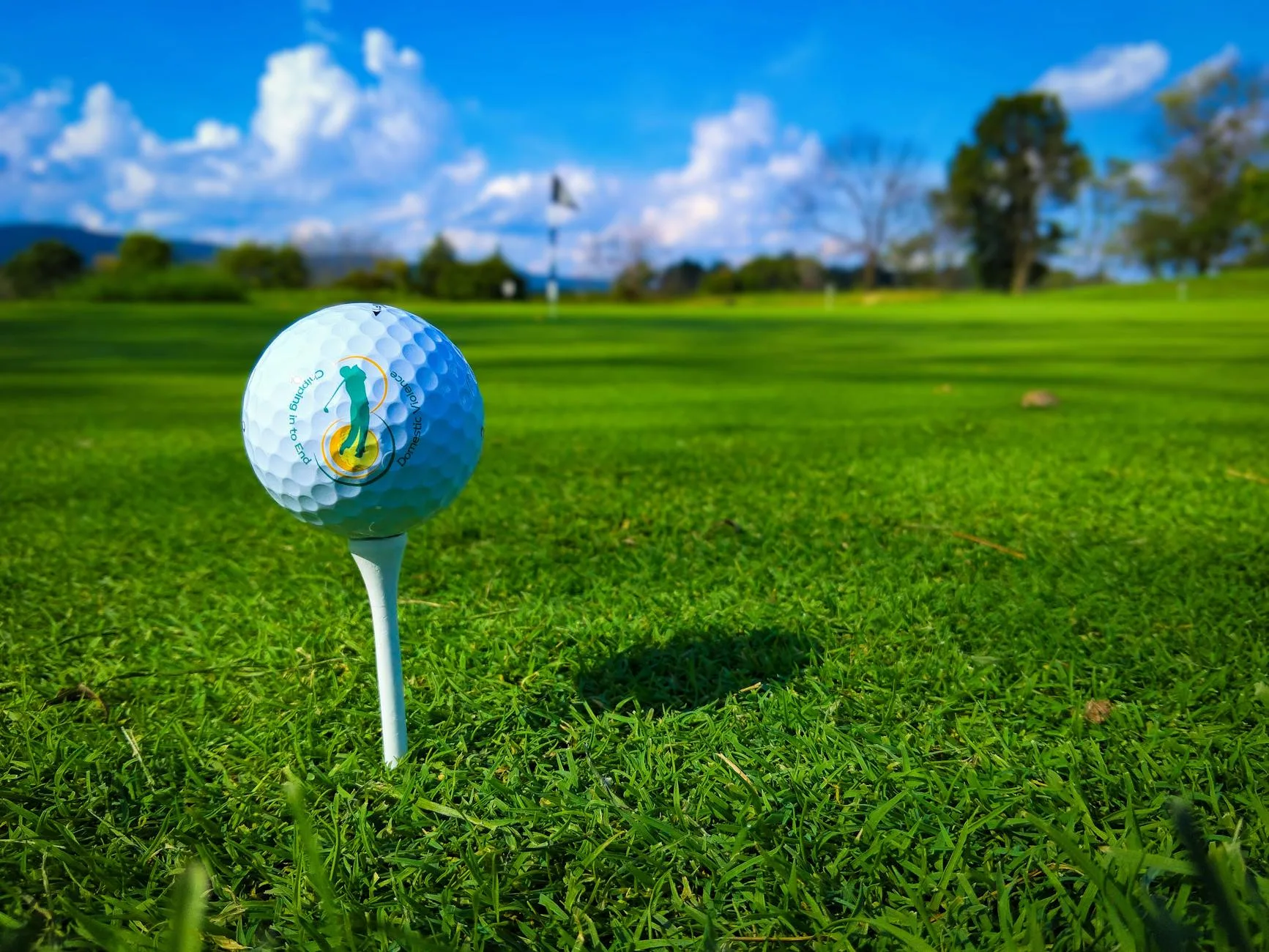 Golf ball on a tee on a sunny golf course