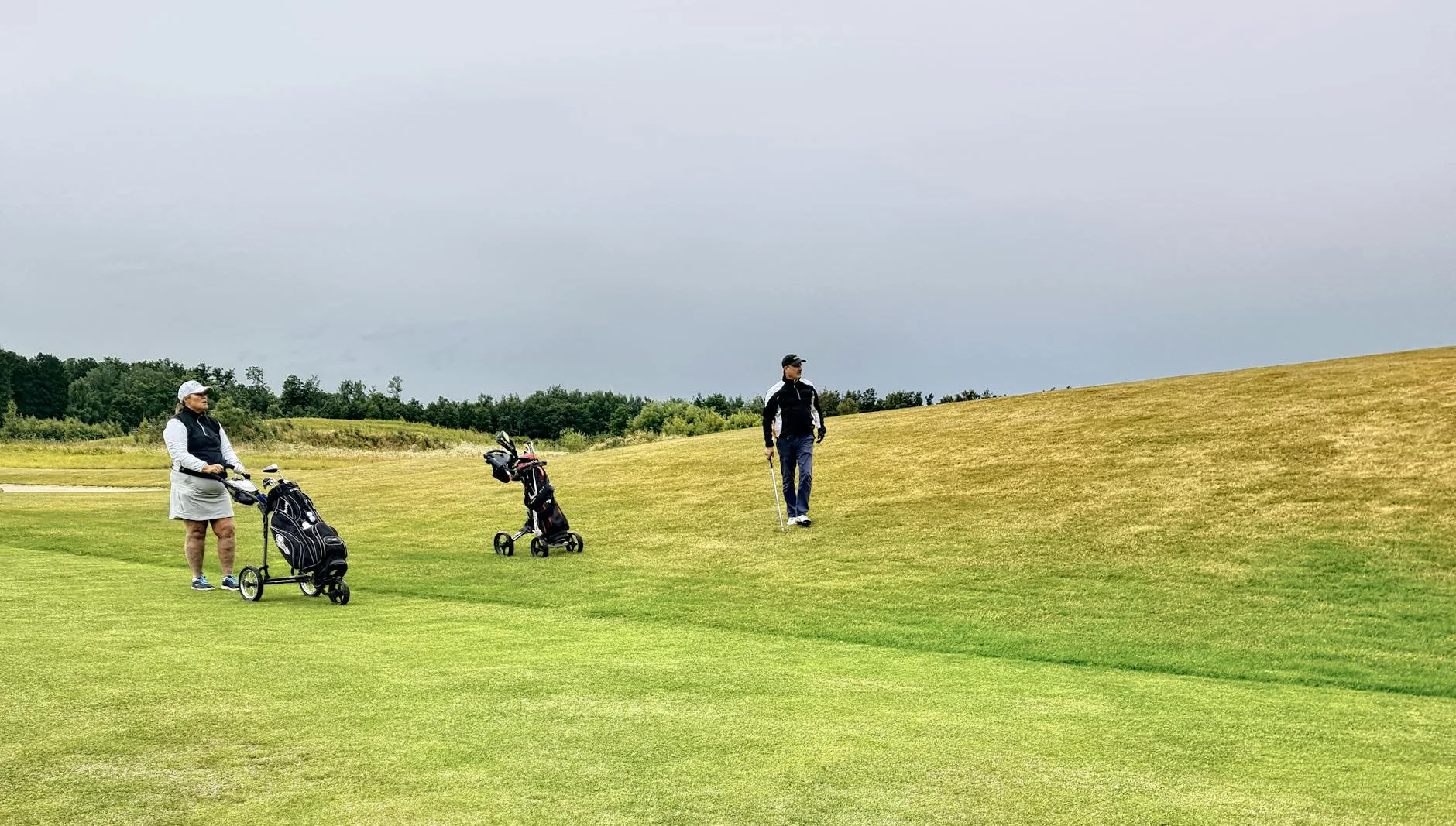 Golf bag with rain cover on a trolley at the course
