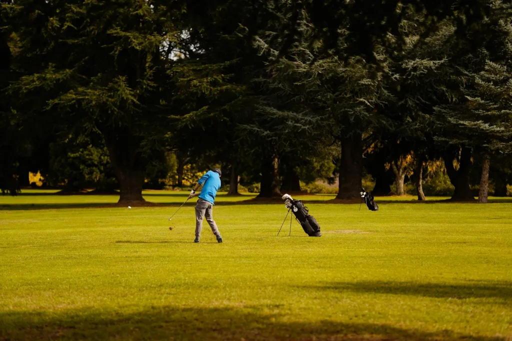 Set of golf clubs in a bag on a golf course with green fairway