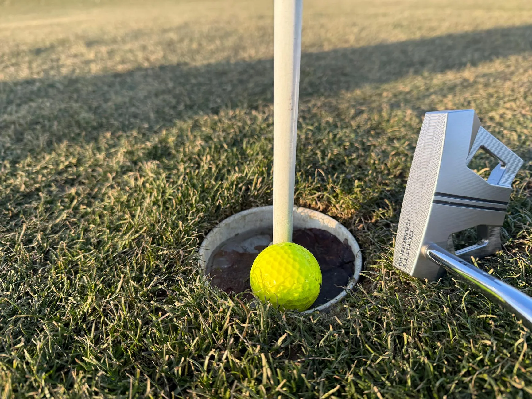 Close-up of golf putter and ball during putting practice