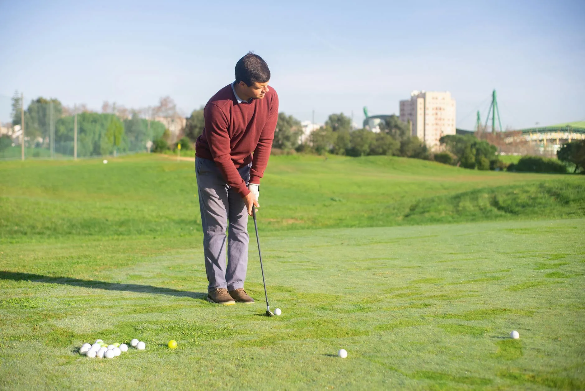 Golfer lining up a putt on a practice putting green