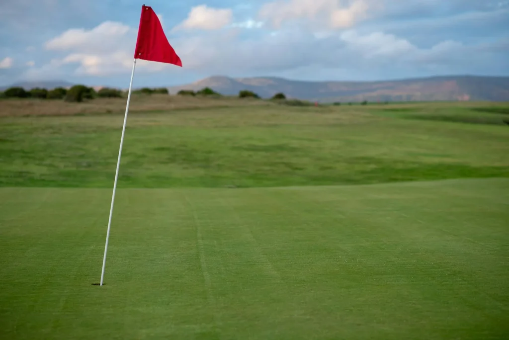 Golf course fairway with flag pin visible in the distance