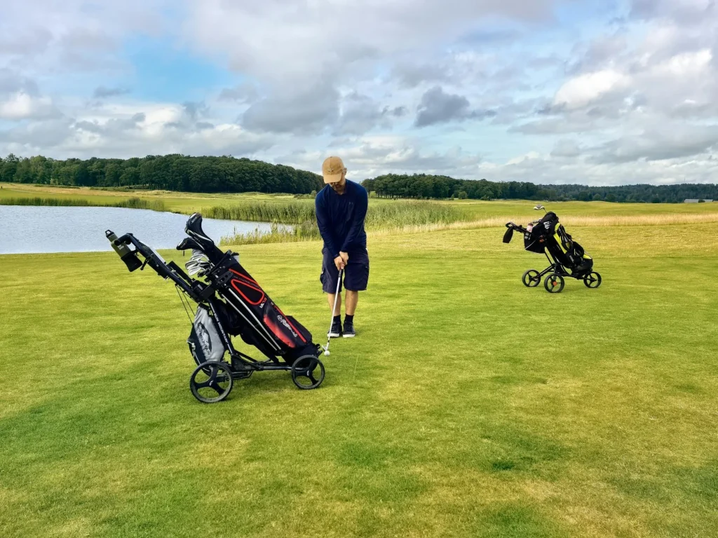 Golf trolley with bag on a green fairway course