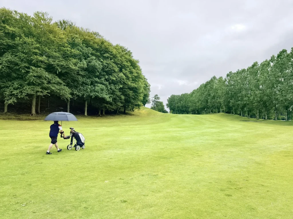 Large golf umbrella open on a golf course during rainy weather
