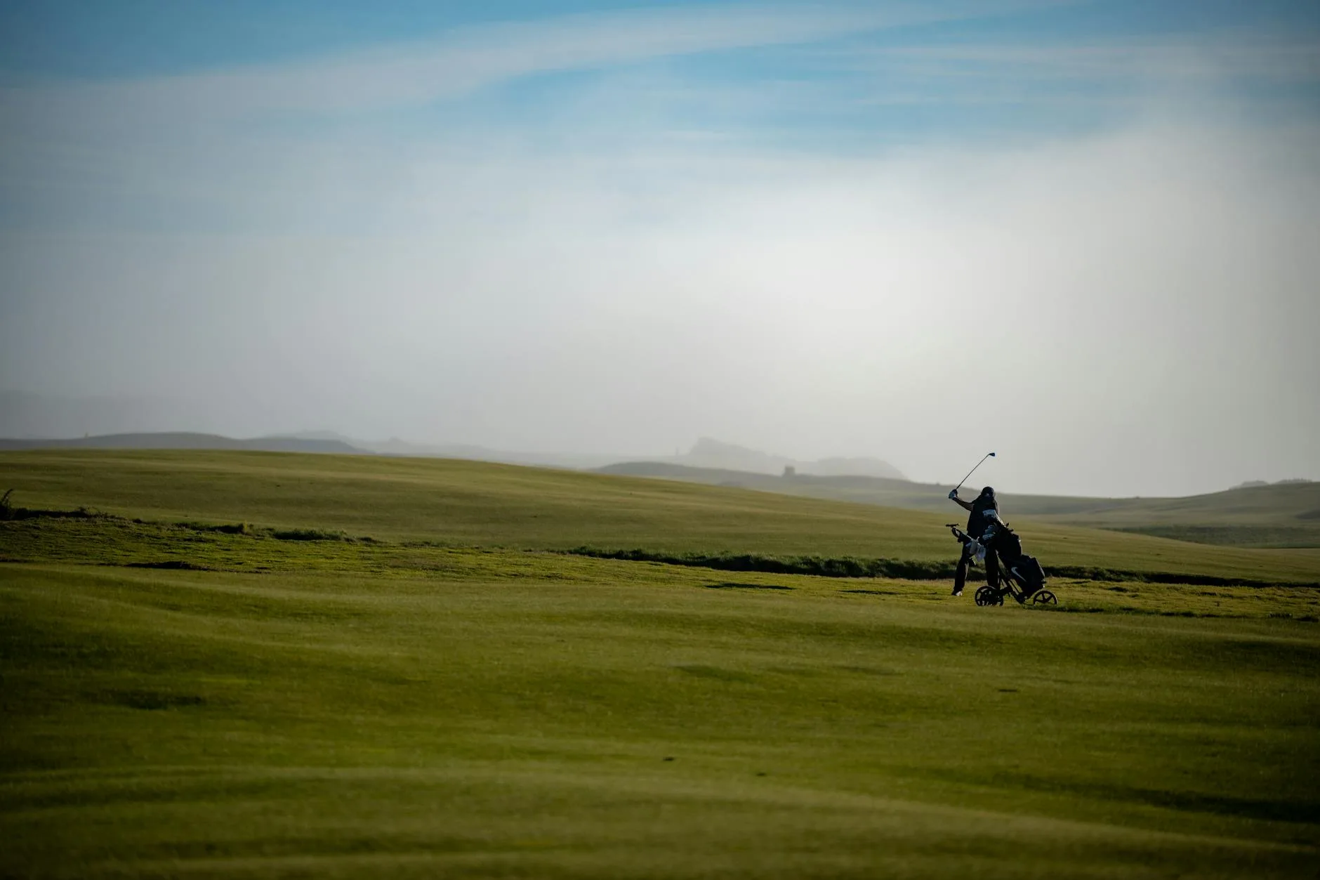 Golfer mid-swing with an iron on the golf course