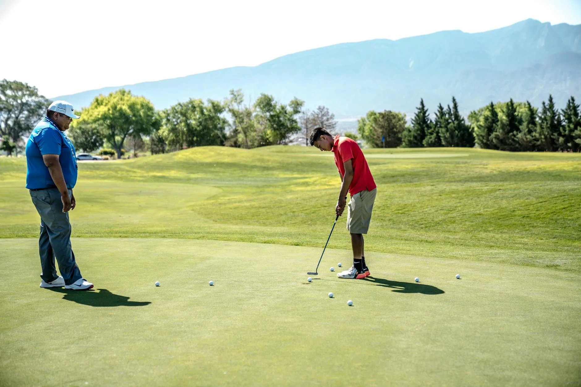 Golfer putting a ball towards the hole on a green