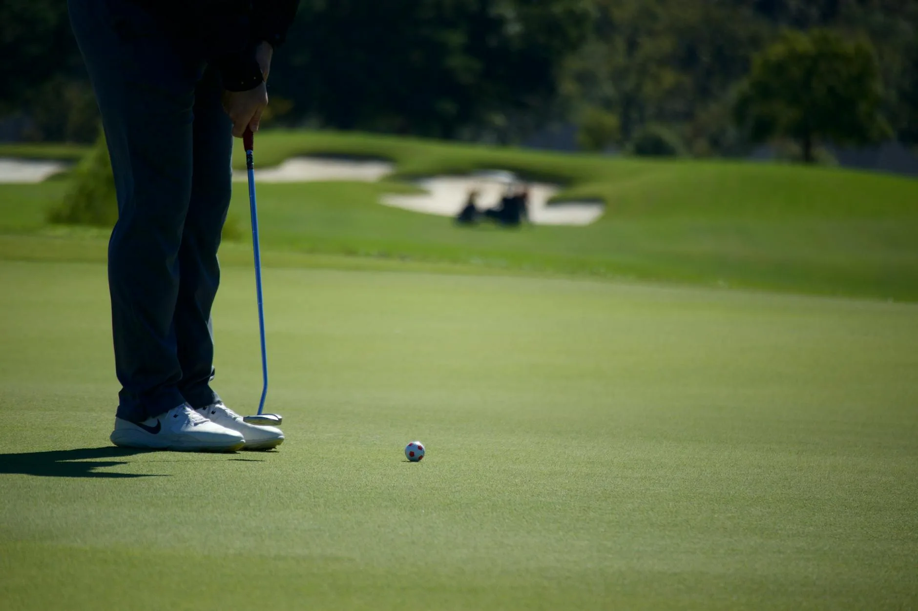 Golfer lining up a putt on a golf course putting green