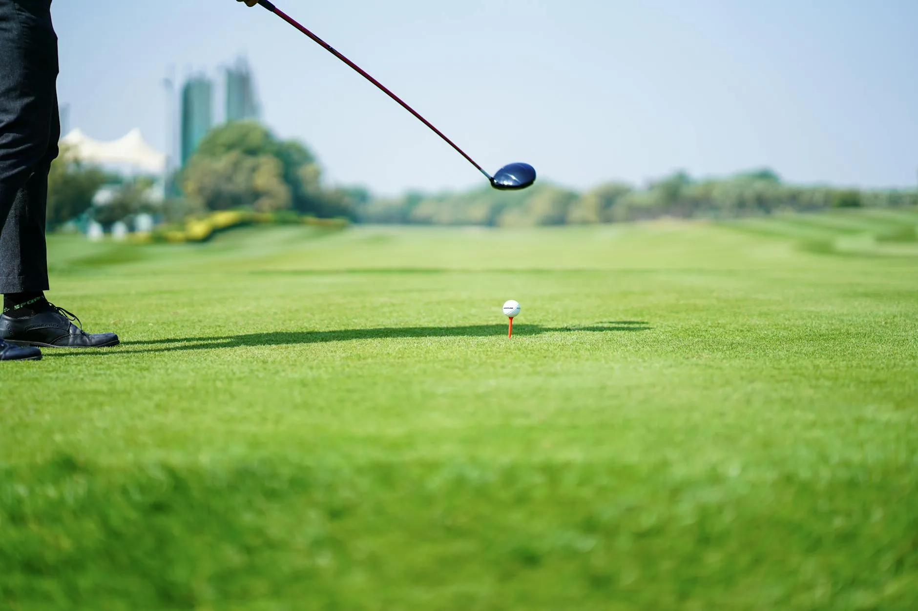 Golfer taking a tee shot on a sunny course
