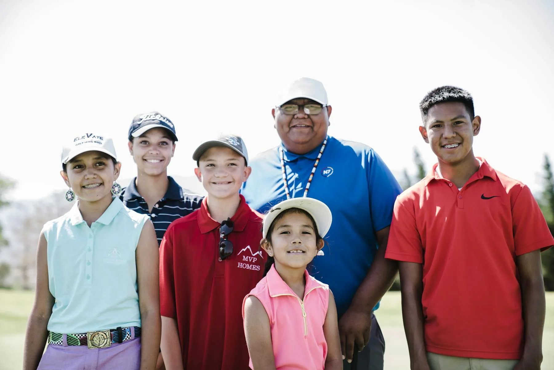 Group of friends laughing together on a sunny golf course during a holiday