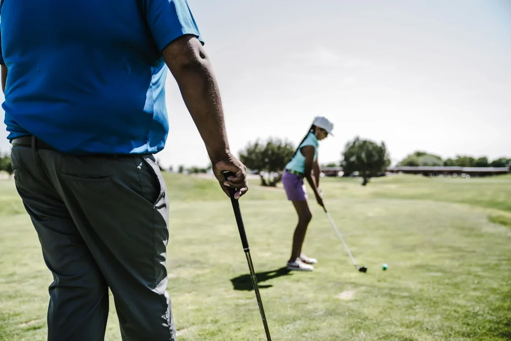 Young junior golfer putting on a green during a round