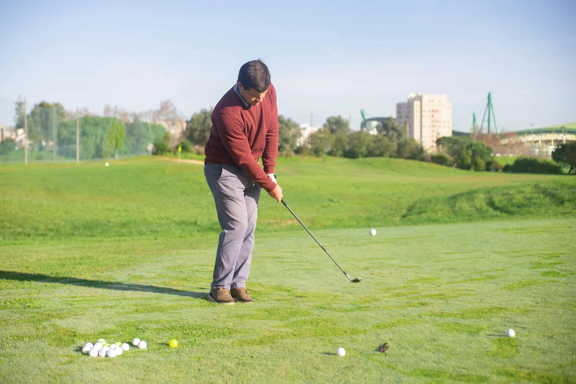 Beginner golfer practising at a driving range