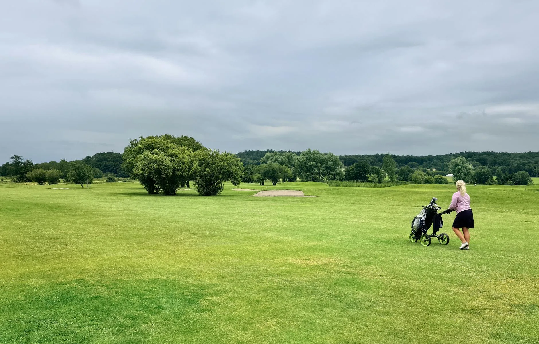 Golf bag on trolley on wet morning course