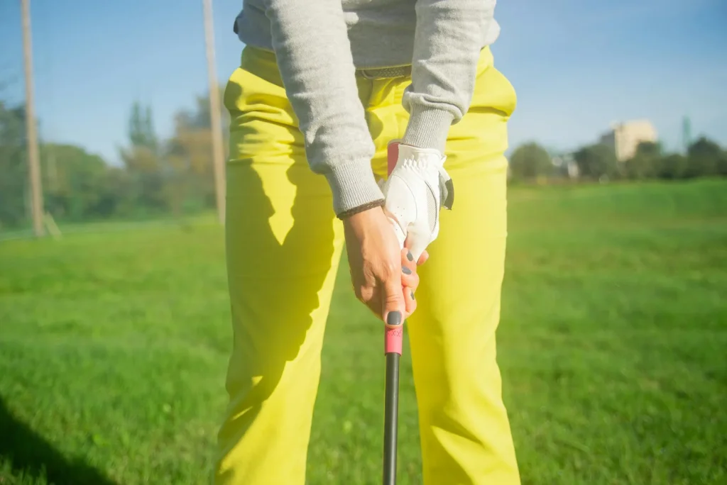Golfer holding an iron showing the rubber grip in closeup