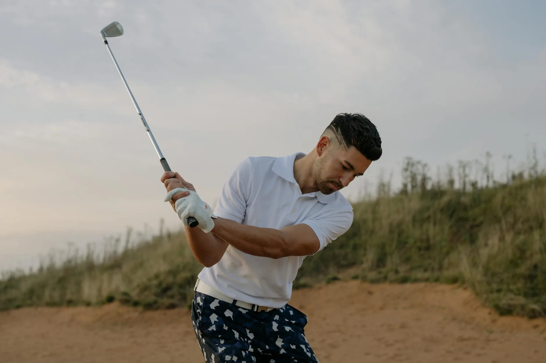 Golf club hitting a ball on a practice mat