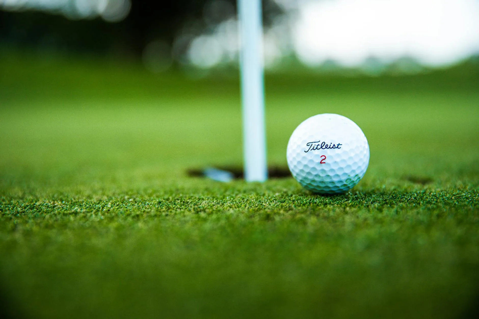 Golf ball near the hole on a putting green during warm-up