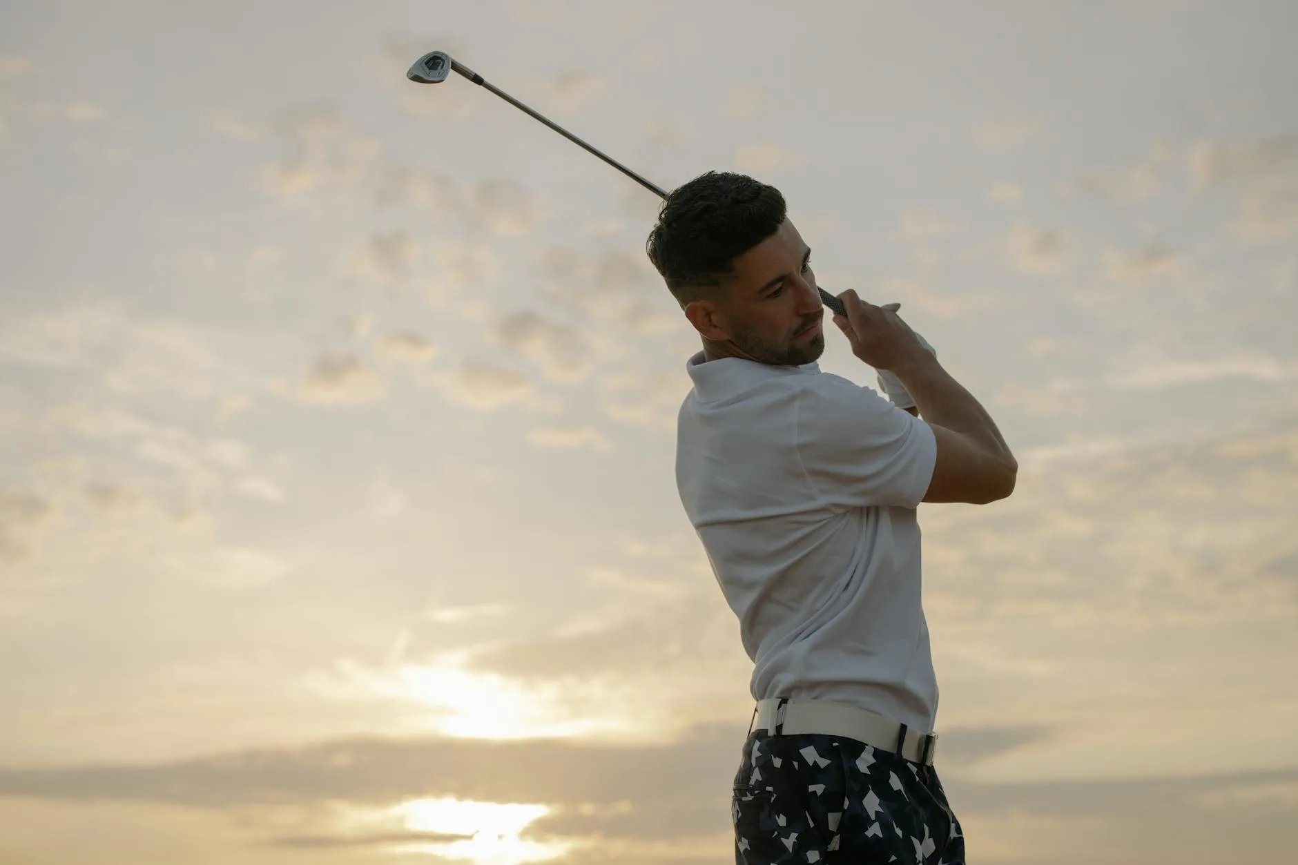 Golfer swinging a club and hitting a ball on the course