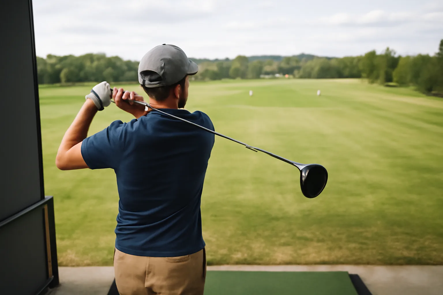 Golfer practising driver from a tee at the driving range