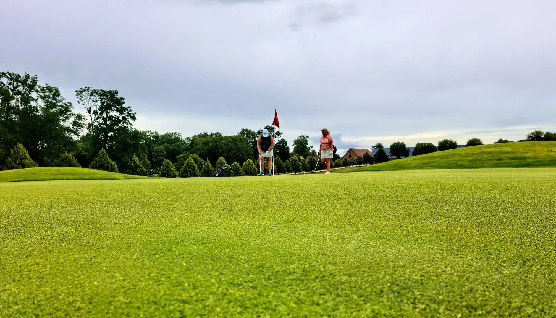 Golfers putting on a green during a club round